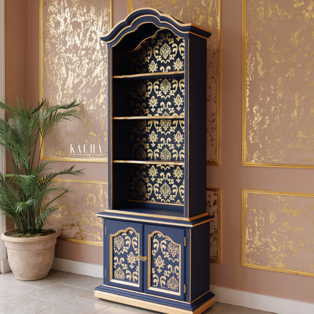 Decorative cabinet with floral patterns in a room with gold-framed artwork on the wall.